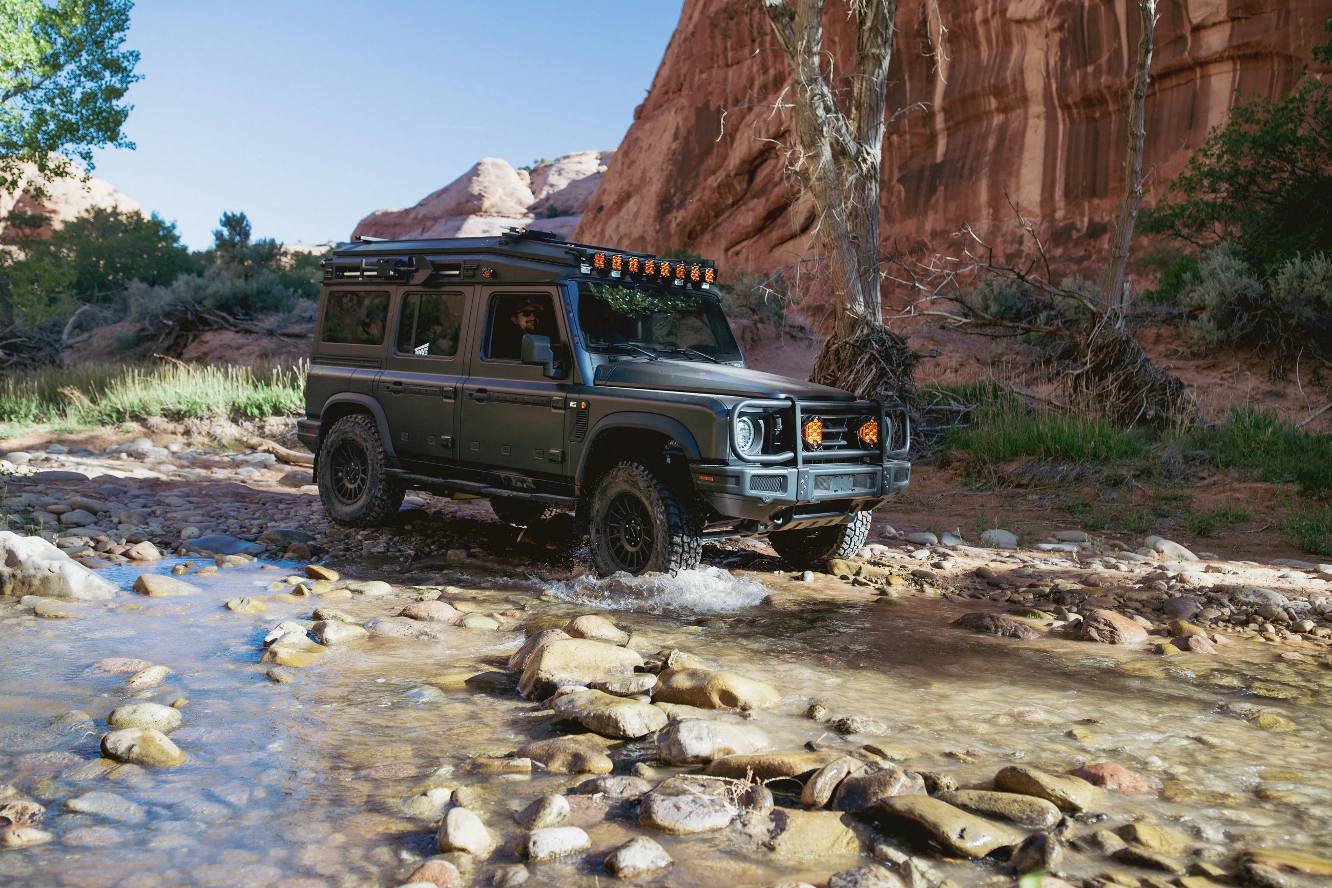 A Grenadier crossing a shallow creek below canyon walls