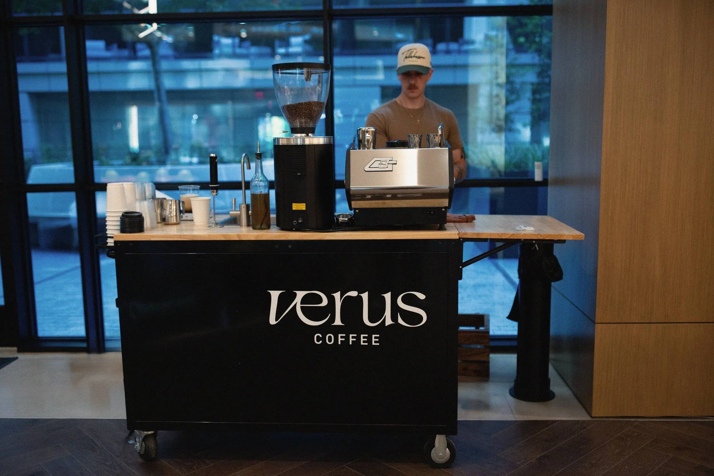 The black Verus coffee cart with a barista and espresso machine